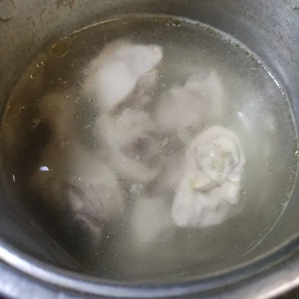 Bersihkan ayam, rebus sebentar di air mendidih, angkat lalu rebus kembali ayam di air yang baru.