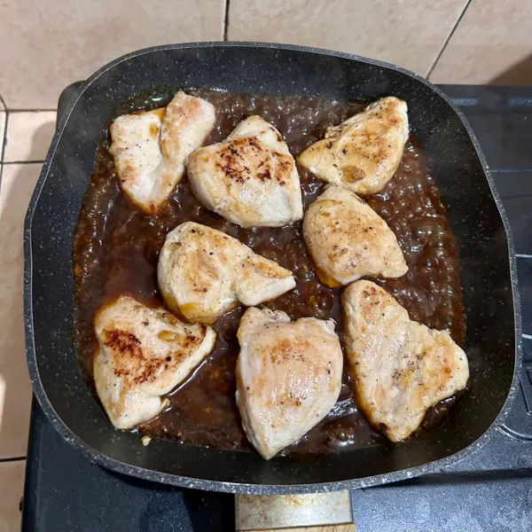 Masukkan campuran saus dan tata ayam yang sudah dipanggang di atas saus. Masak sampai saus mengental dan bolak balik ayam agar saus terserap.