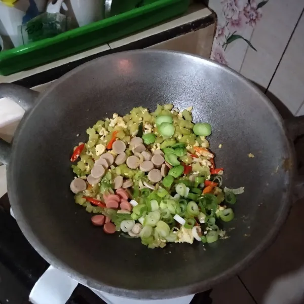 Masukkan irisan sosis, daun bawang dan petai masak hingga petai layu