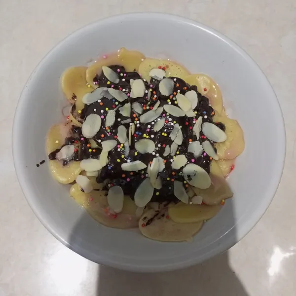 Beri topping pancake mini dengan dark coklat, almond, susu kental strawberry, dan sprinkle