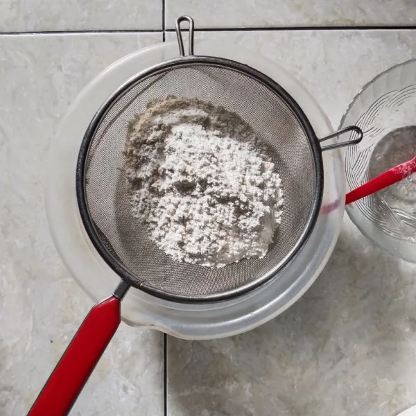 Campurkan tepung terigu dan tepung maizena, lalu ayak. Masukan secara bertahap pada adonan yang sudah putih kental berjejak. Mixer menggunakan kecepatan paling rendah. Jangan terlalu lama, cukup sampai merata saja.