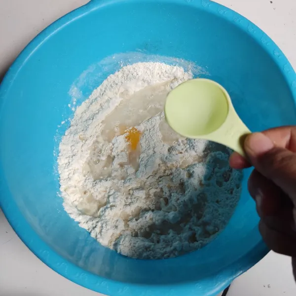 Masukkan kuning telur dan sedikit demi sedikit air dingin. Aduk hingga tercampur rata lalu uleni setengah kalis.