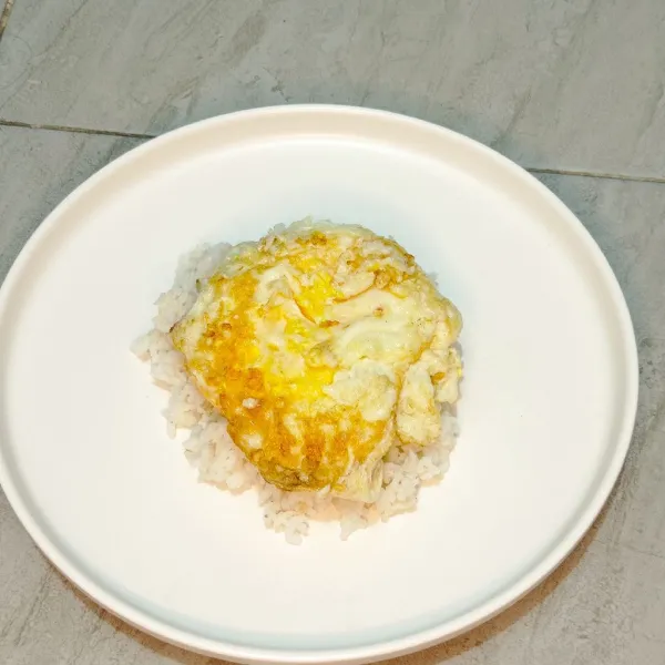 Letakkan telur yang sudah digoreng diatas nasi.