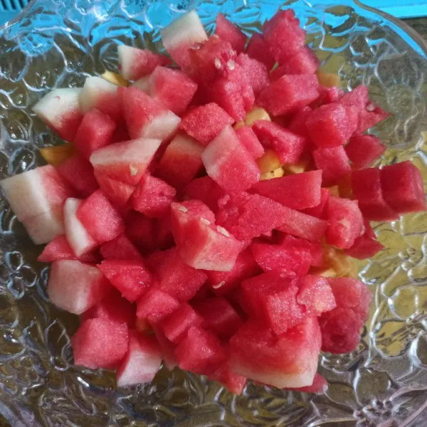 Siapkan wadah, masukkan buah semangka dan nanas yang sudah dipotong-potong.