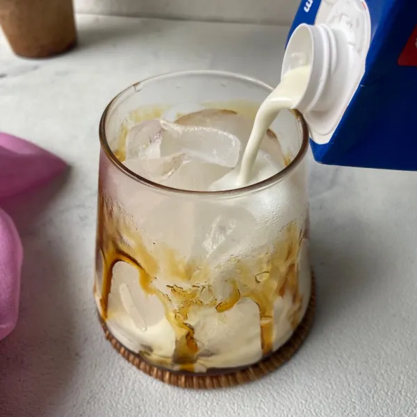 Tuang susu cair hingga 3/4 bagian gelas.