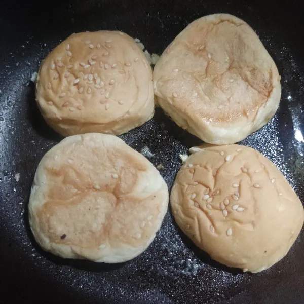 Belah 2 roti bun, kemudian panggang di pan yang telah di oles margarin, panggang hingga kecoklatan.