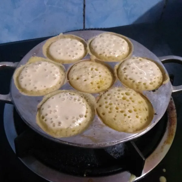 Panaskan cetakan olesi margarin tipis. Tuang adonan martabak hampir penuh. Tunggu sampai berlubang taburi gula pasir.