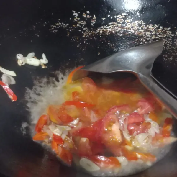 Panaskan minyak tumis bawang hingga harum, masukkan cabe dan tomat, aduk hingga layu.