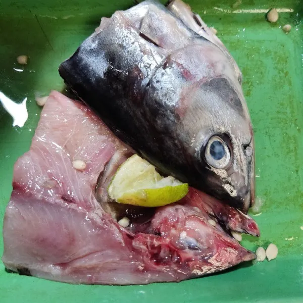 Bersihkan kepala ikan tuna, beri air jeruk nipis, diamkan beberapa menit, lalu bilas.
