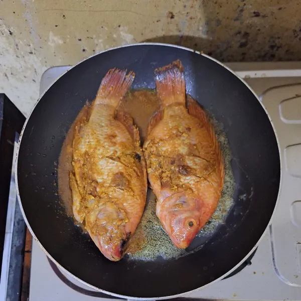 Panaskan teflon dengan api sedang, masukkan margarin panggang ikan nila, oleskan bumbu sisa marinasi agar rasa ikan nila lebih mantap.