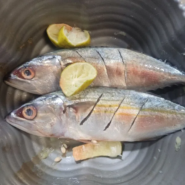 Bersihkan ikan, kerat kedua sisinya kemudian beri air jeruk nipis, diamkan beberapa menit lalu bilas.
