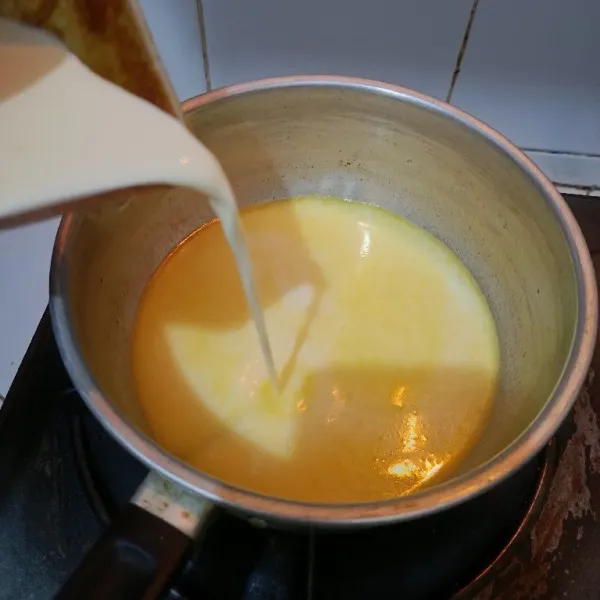 Setelah rebusan susu dan air hangat, masukkan adonan susu dan telur. Masak hingga mendidih sambil diaduk.