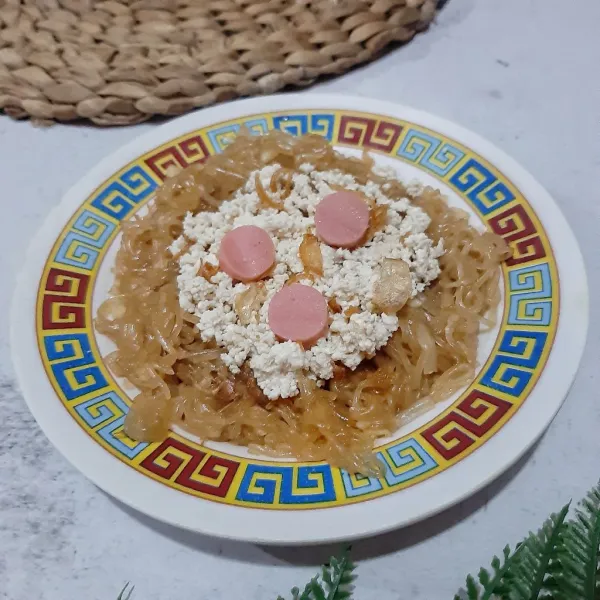 Letakkan bihun di piring, taburi dengan tahu bejek dan bawang goreng. Beri sosis siap makan. Bisa juga sosisnya diberikan bersamaan saat menumis mie ya. Sajikan.