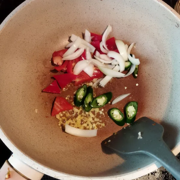 Masukkan paprika, cabai hijau besar, dan bawang bombai masak hingga sedikit layu.