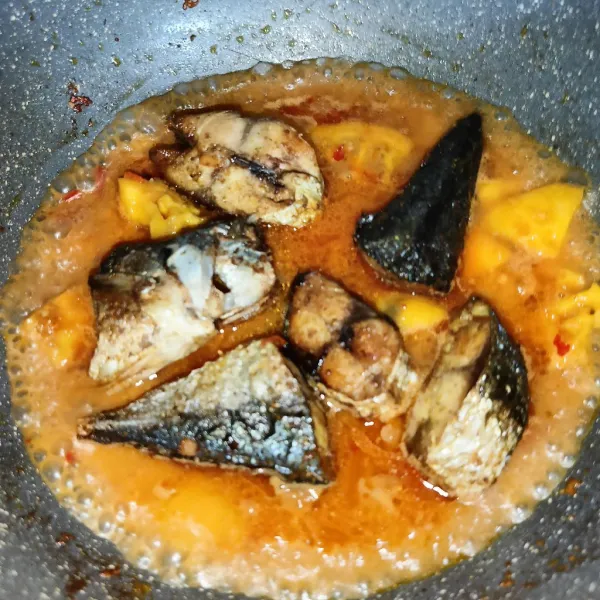 Tuang air dan setelah mendidih masukkan ikan goreng, masak sampai meresap dan matang.