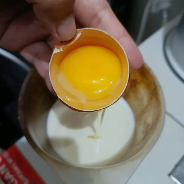 Dalam wadah terpisah, kocok telur dengan susu cair dan air hingga rata.