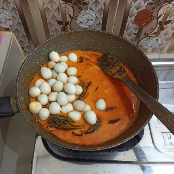 Setelah agak menyusut, masukkan telur puyuh, aduk merata.