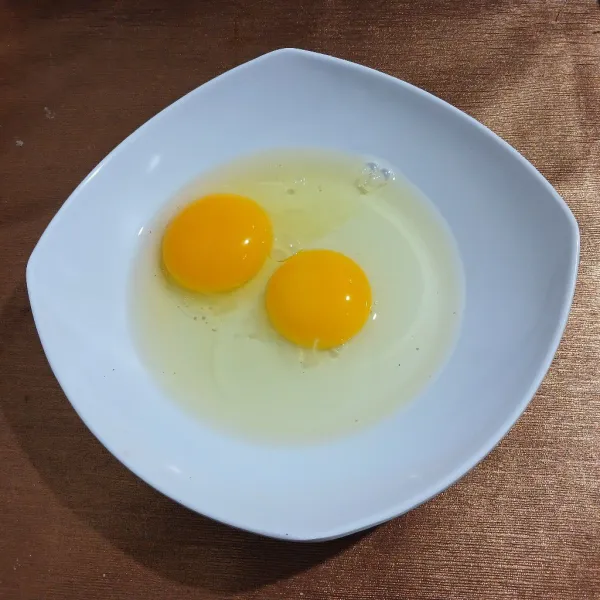 Pecahkan telur di mangkuk. Kocok rata dengan garpu.