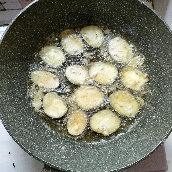 Panaskan minyak goreng, celupkan terong ke dalam tepung, angkat dan goreng hingga kecoklatan.