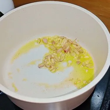 Lelehkan mentega lalu tumis bawang merah dan bawang putih hingga harum dan matang.