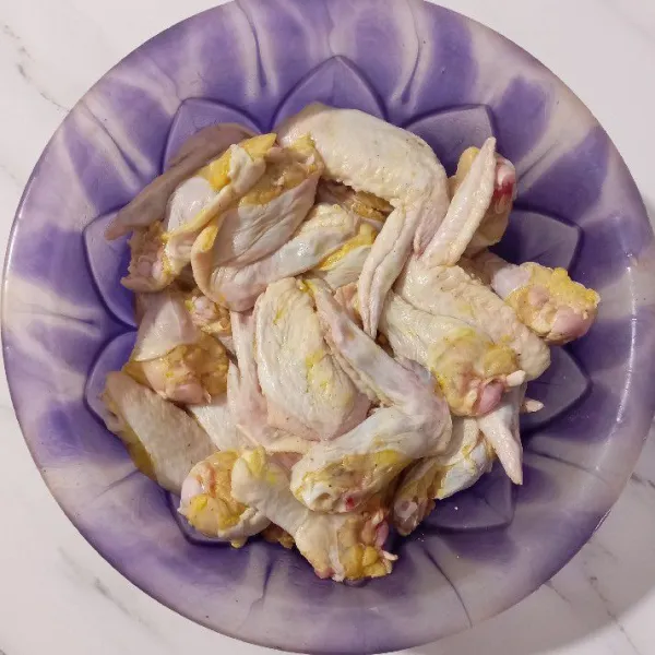 Bersihkan ayam, kemudian potong dua, selanjutnya marinasi selama 15 menit.
