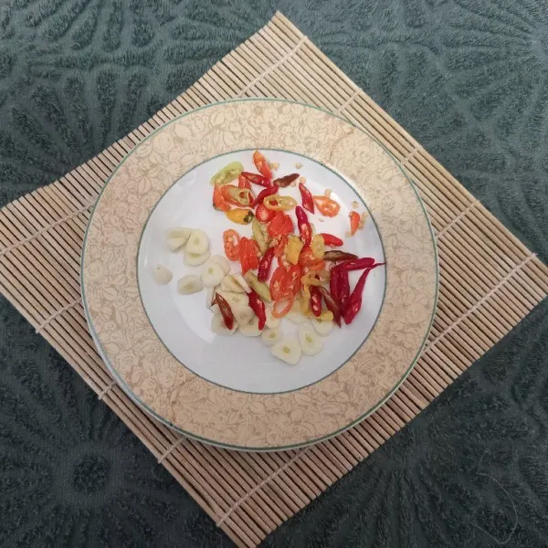 Potong-potong cabe rawit merah, cabe rawit kecil merah dan bawang putih.