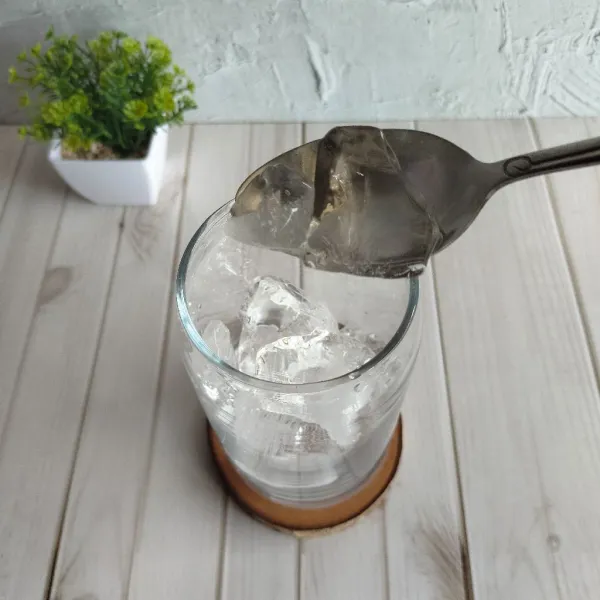 Masukan es batu kedalam gelas saji.