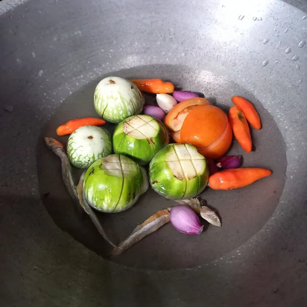 Rebus terong, tomat, teri, bawang merah, bawang putih, dan cabai sampai air menyusut.