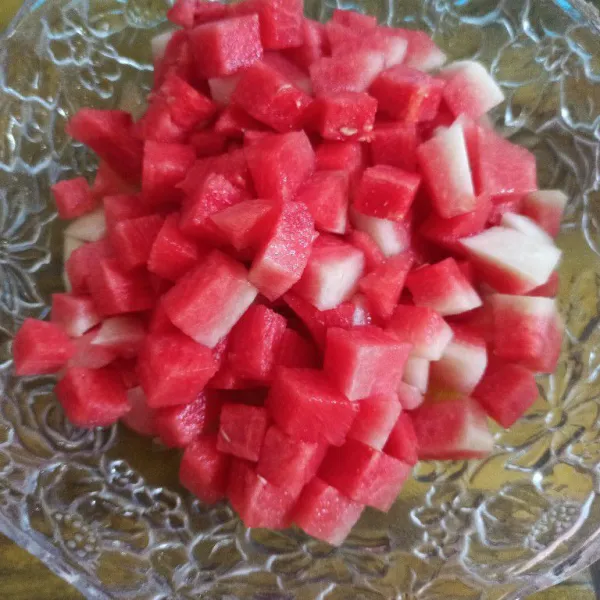 Potong-potong buah semangka dan masukkan kedalam mangkuk berisi melon serut.