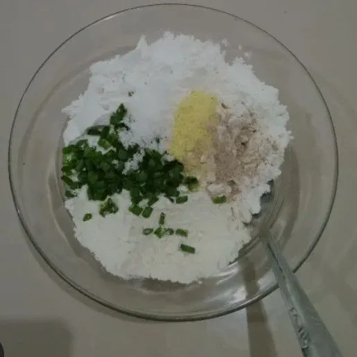 Masukkan tepung terigu, tepung tapioka, bawang putih halus, isian tahu, daun bawang, garam dan penyedap ke dalam wadah aduk sampai rata.