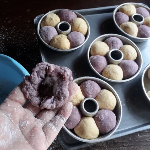 Kempiskan masing - masing adonan. Timbang seberat 20 gr, pipihkan isi dengan selai cokelat, bulatkan. Letakkan dalam loyang tulban mini yang dioles margarin. Letakkan selang seling kuning dan ungu.