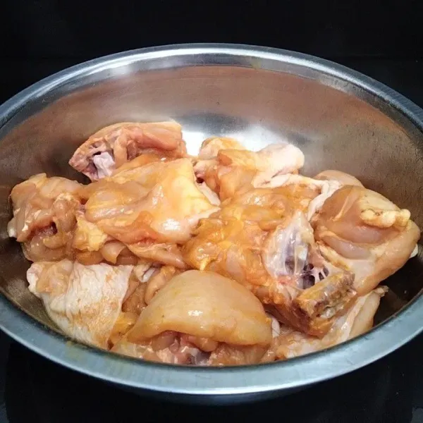 Langkah awal marinasi daging ayam yang sudah dicuci bersih menggunakan kunyit bubuk dan juga garam selama minimal 30 menit.