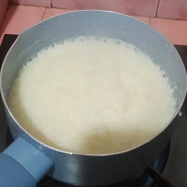 Tuang nasi ke dalam panci, tuang sisa air dan masak sampai nasinya lembut.
Tata bubur di mangkuk, beri ayam suwir, kuah kuning, bawang goreng dan irisan daun bawang dan sambal. Tambahkan kecap asin dan kecap manis jika suka.