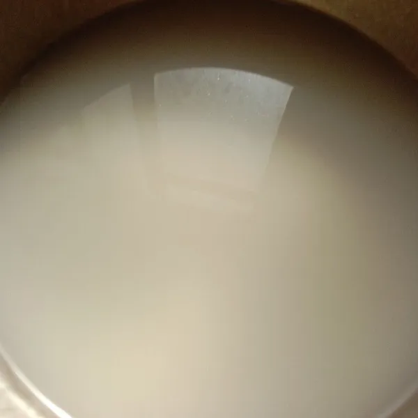 Masukkan susu cair sedikit demi sedikit sambil terus diaduk hingga tercampur rata.