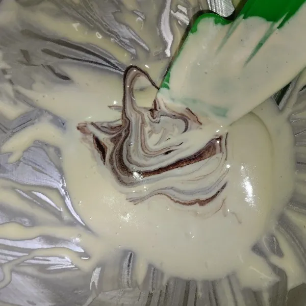 Ambil 5 sendok adonan dan beri pasta coklat aduk rata. Masukkan ke dalam piping bag.