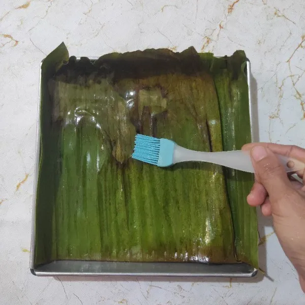 Siapkan loyang yang sudah di alas daun pisang lalu olesi dengan sedikit minyak sayur.