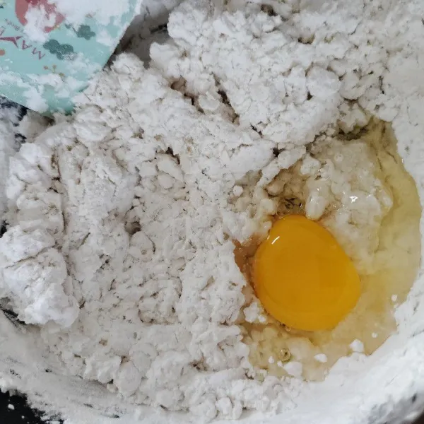 Tambahkan tepung tapioka, aduk hingga rata. Masukkan telur, keju parut .