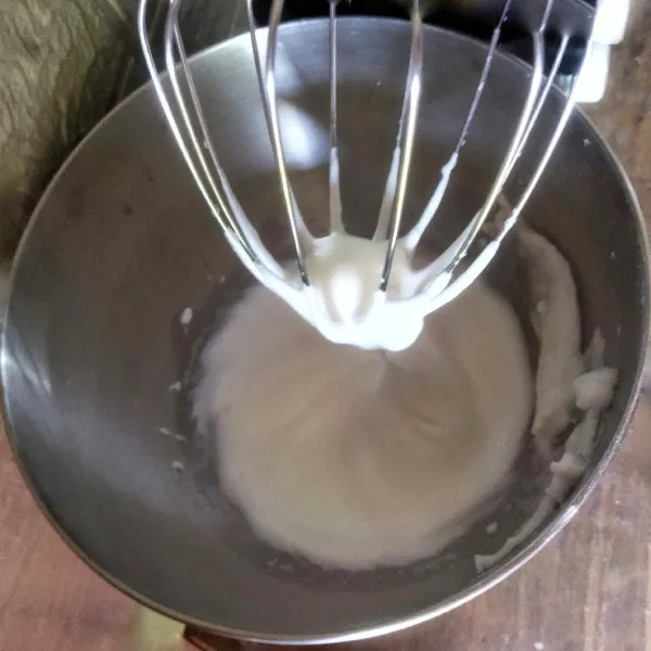 Kocok putih telur dengan mixer hingga ½ kaku, kemudian masukkan gula pasir secara berkala ke dalam putih telur. Kocok hingga membentuk meringue. Sisihkan.