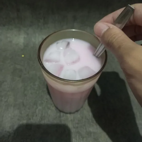 Tambahkan es batu lagi agar memenuhi gelas dan aduk soda gembira, lalu sajikan.