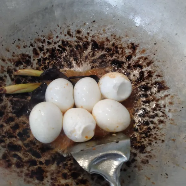 Masukan 6 butir telur rebus ke dalam bumbu yang telah panas. Aduk sebentar. Lalu tambahkan 500 ml air, garam, penyedap rasa, dan gula sesuai selera. Lalu aduk hingga semua tercampur. Setelah itu diamkan hingga mendidih.