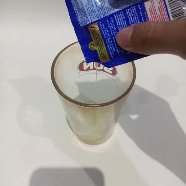 Lalu tuangkan susu kental manis juga ke dalam gelas saji