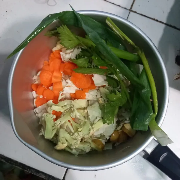 Cuci bersih dan potong semua sayuran sop. Untuk daun bawang dan seledri sisihkan dulu.