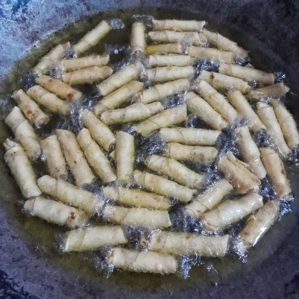 Panaskan minyak sayur dengan api sedang dan goreng sumpia hingga kuning kecoklatan, angkat dan tiriskan. Sajikan sumpia udang rebon pedas manis sebagai pengisi toples di hari raya!