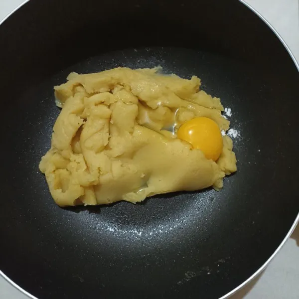 Setelah agak dingin, campur adonan dengan 2 butir telur, aduk merata sampai menjadi adonan yang kental.