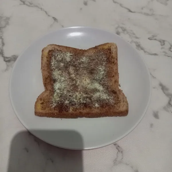 Letakkan roti pada piring saji dan taburi dengan susu bubuk vanilla, lalu roti pun siap disajikan
