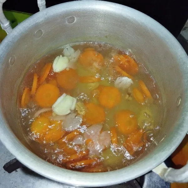 Didirikan air, rebus wortel dulu bersama dengan bawang merah, bawang putih dan temu kunci geprek.