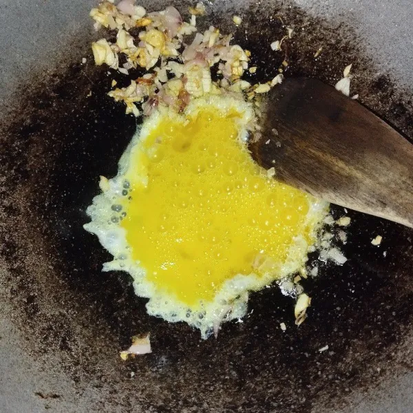 Tumis bawang putih dan bawang merah sampai harum, lalu sisihkan di pinggir wajan. Masukkan telur dan bikin orak-arik.