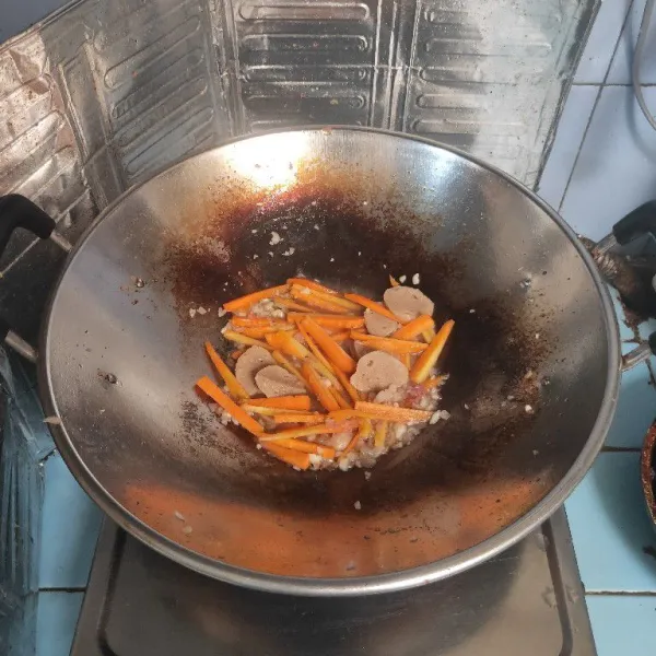 Tuang air, masukkan potongan wortel dan bakso, masak hingga setengah matang.
