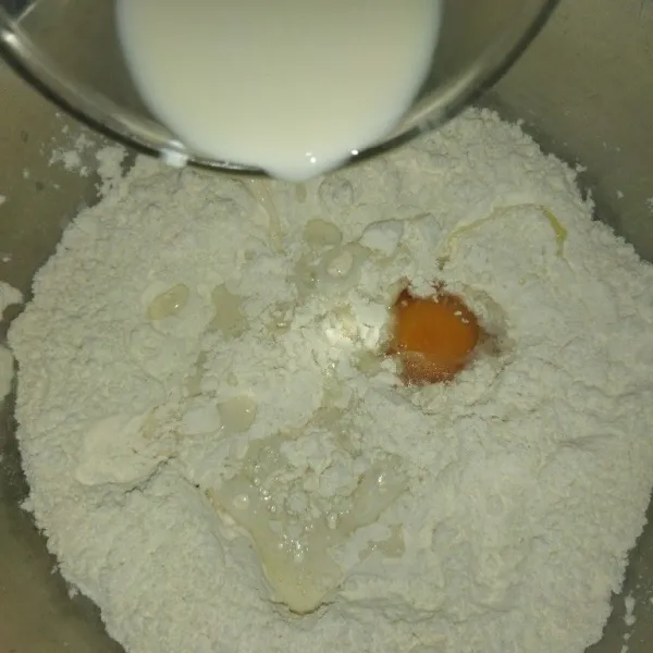 Campur tepung terigu, ragi instan dan gula pasir, lalu tambahkan telur dan susu cair, uleni hingga adonan setengah kalis.