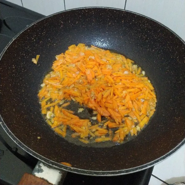 Masukan irisan wortel, masak hingga layu